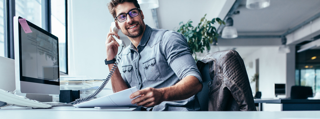 Foto: Ausbilder spricht am Festnetztelefon im B&uuml;ro.